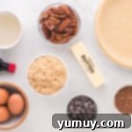Overhead view of all chocolate pecan pie ingredients, including pecans, chocolate chips, and liquids, neatly laid out before mixing.