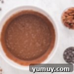 The chocolate and egg mixtures fully combined to form the rich chocolate pecan pie filling in a white bowl.