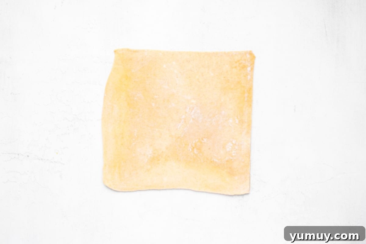 Flaky Pie Crust Apple Delights 11 Pie dough rolled out into a rectangle and cut into squares, ready for filling.