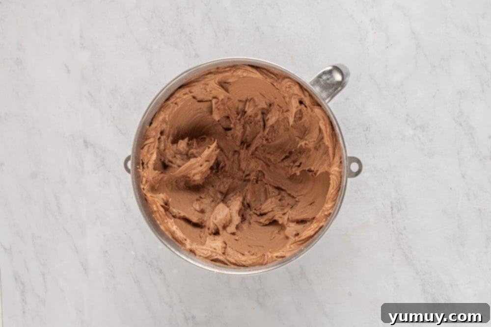 Decadent Chocolate Strawberry Delight 12 A bowl brimming with rich, expertly prepared chocolate frosting, featuring a smooth and creamy texture, ready to be used.