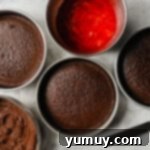 Decadent Chocolate Strawberry Delight 6 An overhead view displaying three perfectly baked chocolate cake layers, cooling on a wire rack, alongside bowls of strawberry filling and chocolate frosting, ready for assembly.