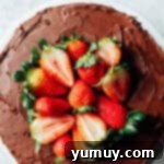 Decadent Chocolate Strawberry Delight 9 An overhead view of a beautifully frosted chocolate strawberry cake, elegantly garnished with vibrant fresh strawberries on top, showcasing its festive appeal.