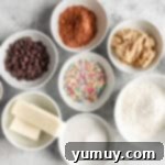 Overhead view of ingredients for cosmic brownie cookies in white bowls.