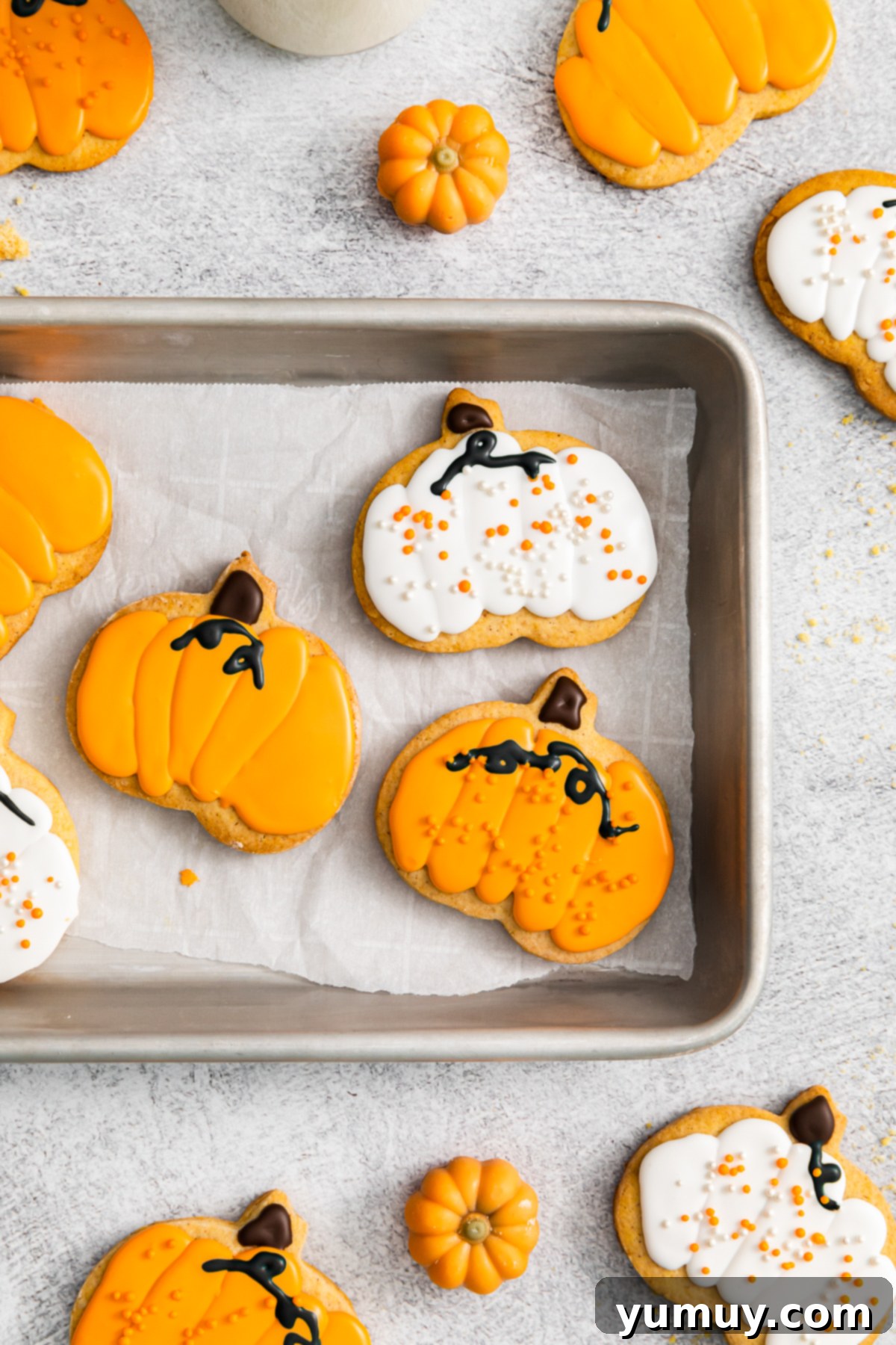 pumpkin sugar cookies, some with orange frosting, some with white frosting