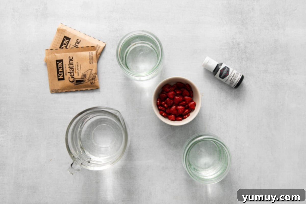 Overhead view of all ingredients for Grinch jello shots laid out on a clean surface, ready for preparation.