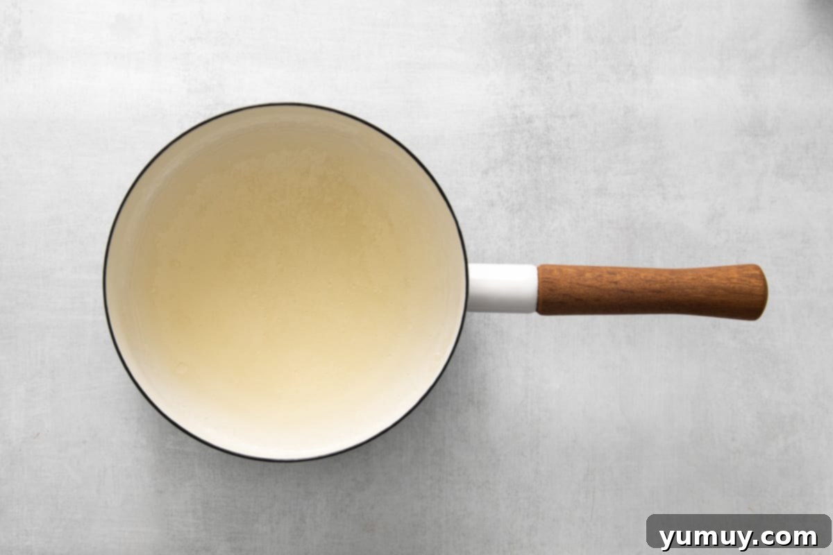 Water and unflavored gelatin granules resting in a saucepan before heating.