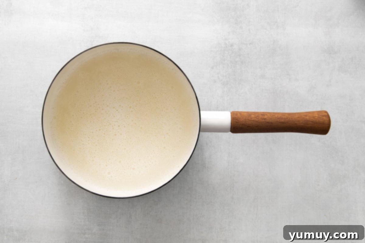 Cooked water and dissolved gelatin in a saucepan, now a clear liquid.