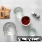 Overhead view of all ingredients for Grinch jello shots laid out on a clean surface, ready for preparation.