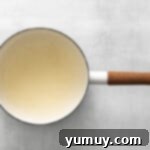 Water and unflavored gelatin granules resting in a saucepan before heating.