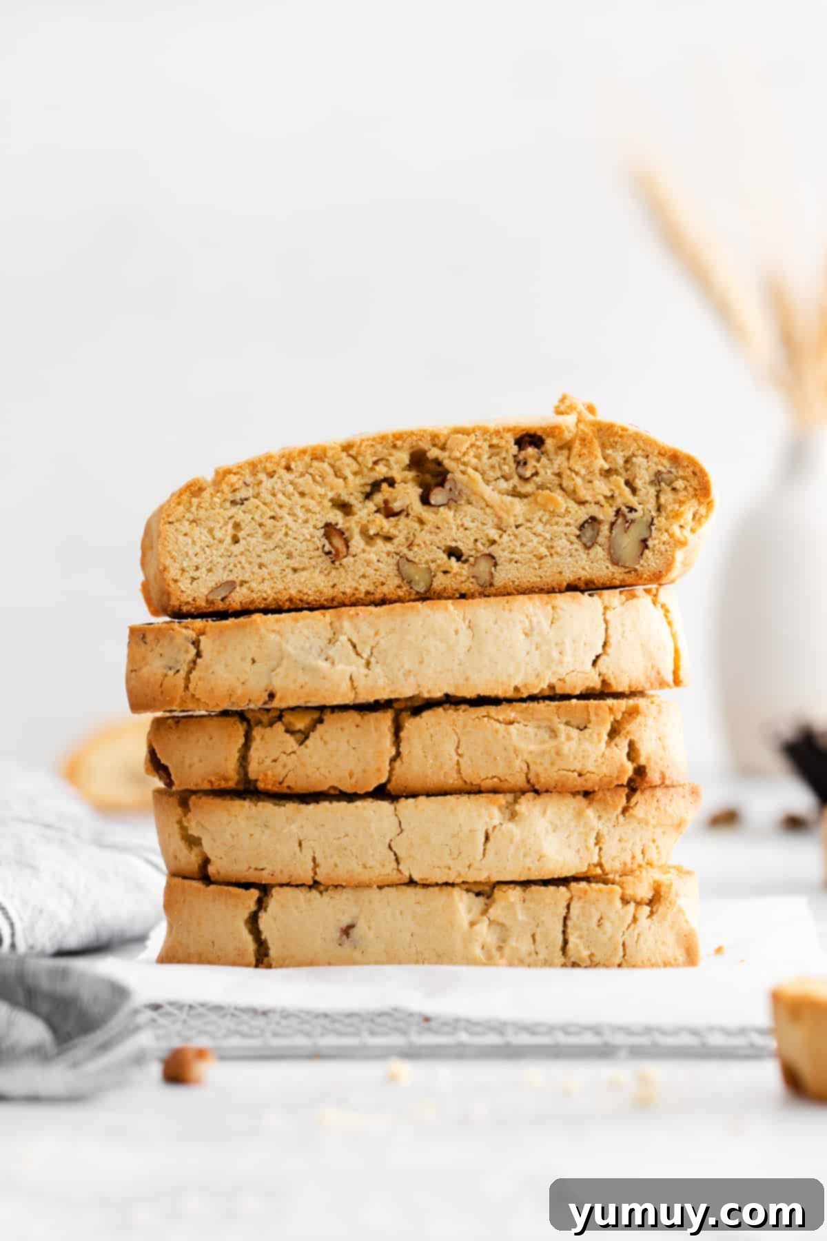 a stack of freshly baked maple pecan biscotti on parchment paper.