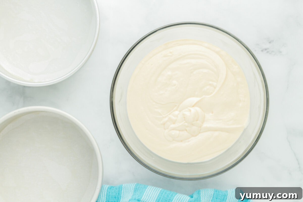 Winged Whimsy Cake 7 Overhead view of the smooth, prepared airplane cake batter swirling in a glass bowl, ready for baking.