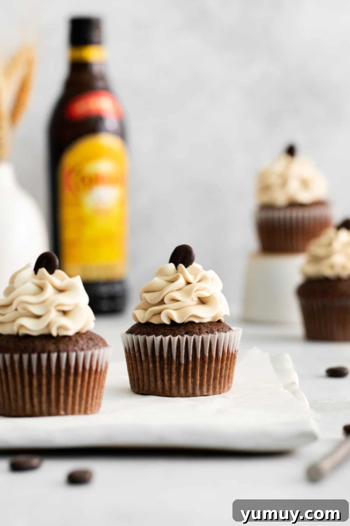 Two Kahlua cupcakes, beautifully frosted and arranged on a rectangular white plate, showcasing their inviting appearance.