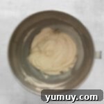 Smooth and fluffy Kahlua buttercream, beautifully prepared in a gleaming stainless steel mixing bowl.