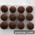 Twelve perfectly filled Kahlua cupcakes patiently resting on a wire rack, awaiting their delightful frosting.