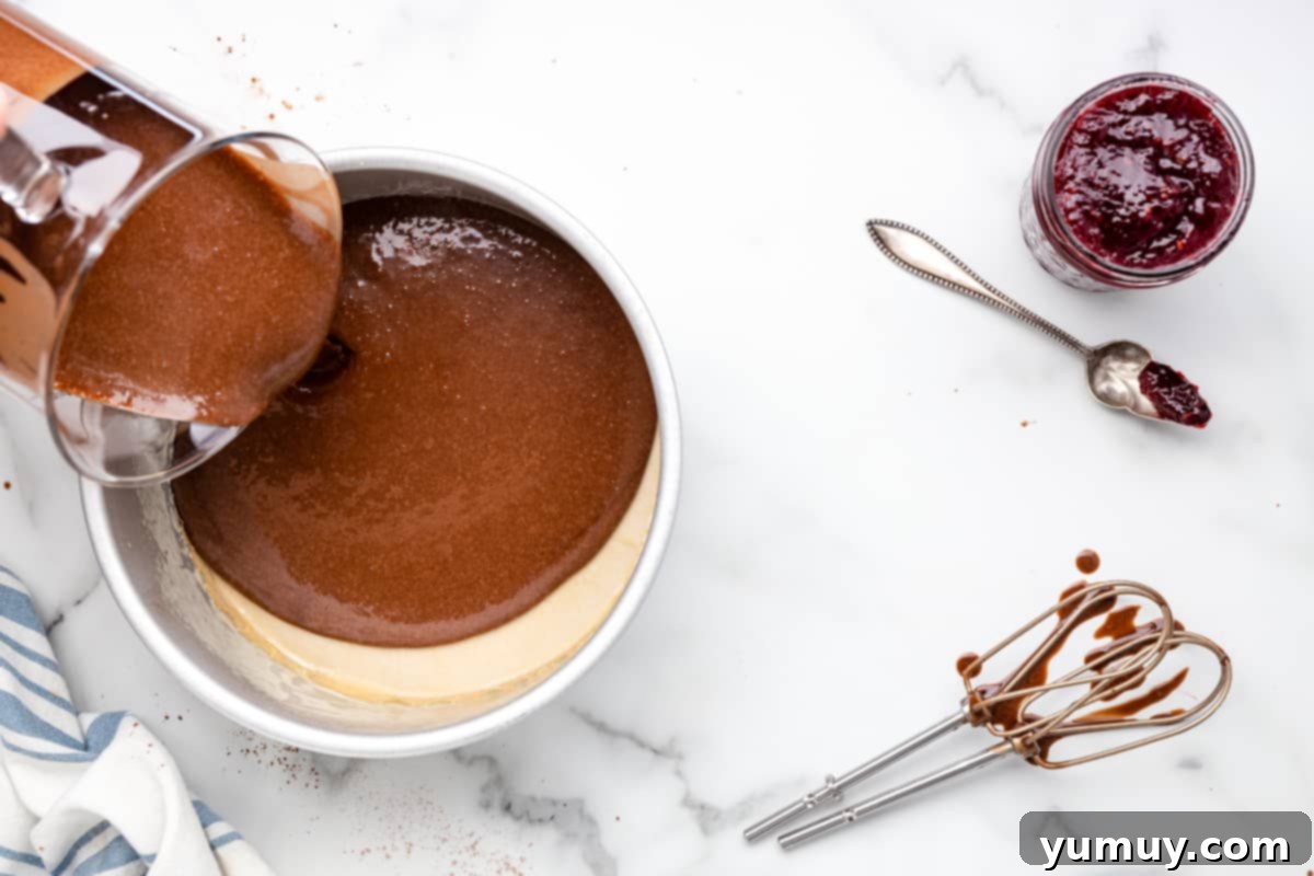 Dark Chocolate Raspberry Gateau 12 chocolate cake batter poured into a cake pan next to hand mixer beaters.