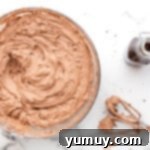 Dark Chocolate Raspberry Gateau 8 chocolate buttercream in a glass bowl next to hand mixer beaters.