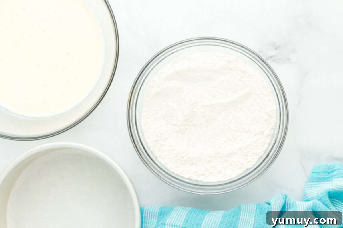 wet and dry ingredients for doctored white cake mix separated into glass bowls, illustrating careful preparation.