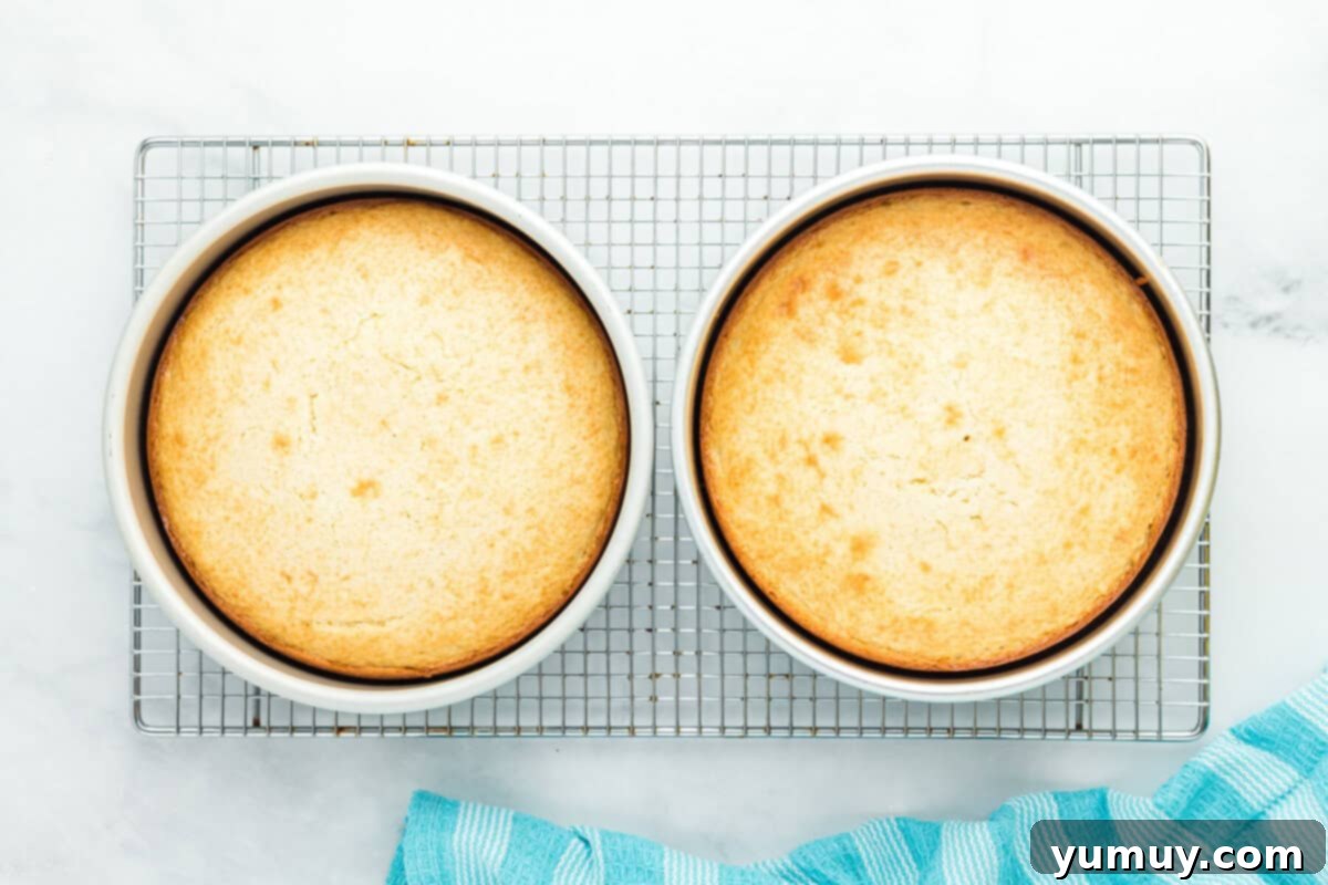 baked layers of doctored white cake mix cooling on a wire rack after being removed from round cake pans.