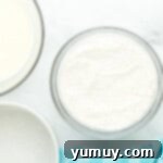 wet and dry ingredients for doctored white cake mix in separate glass bowls, ready for mixing.