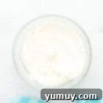 creamy homemade buttercream frosting for doctored white cake mix in a glass bowl.