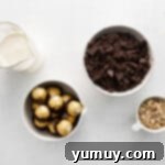 Overhead view of ingredients for Ferrero Rocher cupcake ganache and buttercream: chopped chocolate, heavy cream, and hazelnuts.