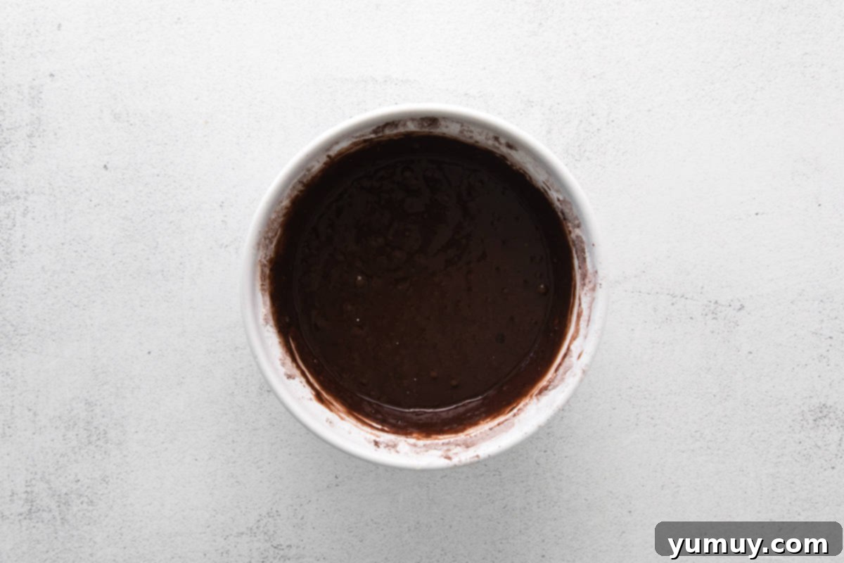 Caramel Coconut Chocolate Bliss Cupcakes 11 The rich chocolate batter swirls smoothly in a large mixing bowl, a promise of deliciousness.