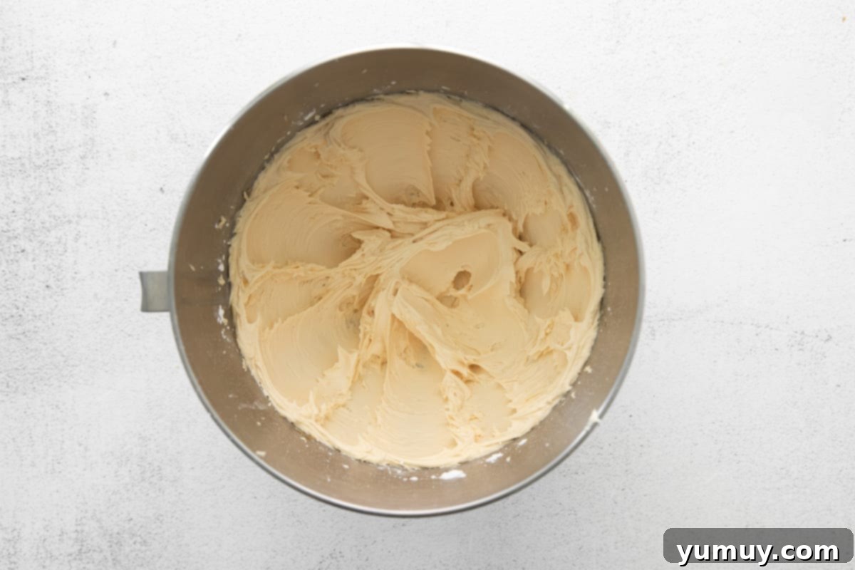 Caramel Coconut Chocolate Bliss Cupcakes 14 Silky smooth caramel buttercream is expertly whipped in a mixing bowl, ready to crown the cupcakes.