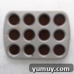 Caramel Coconut Chocolate Bliss Cupcakes 7 Cupcakes in a pan, each filled with precisely portioned batter, ready for baking.