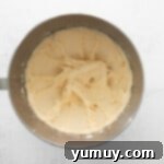 Caramel Coconut Chocolate Bliss Cupcakes 9 Smooth, creamy buttercream is being mixed in a stand mixer, ready to be piped onto cupcakes.