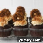 Caramel Coconut Chocolate Bliss Cupcakes 10 A delectable group of frosted cupcakes, artfully decorated and arranged on a wire rack.