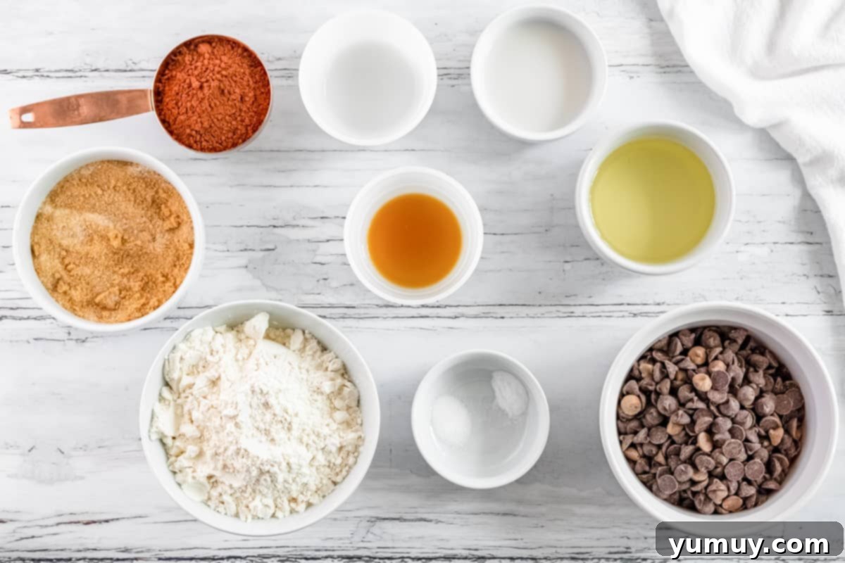 Overhead view of all ingredients for homemade Thin Mints laid out in individual bowls, including flour, cocoa powder, sugar, oil, milk, and extracts.