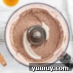 Mixed dry ingredients for Thin Mints in a food processor, showing the dark cocoa and white flour blend.