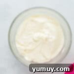 Cream cheese frosting in a glass bowl, perfectly whipped and smooth.