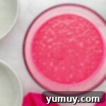 Pink velvet cake batter in a glass bowl, mixed to a smooth consistency.