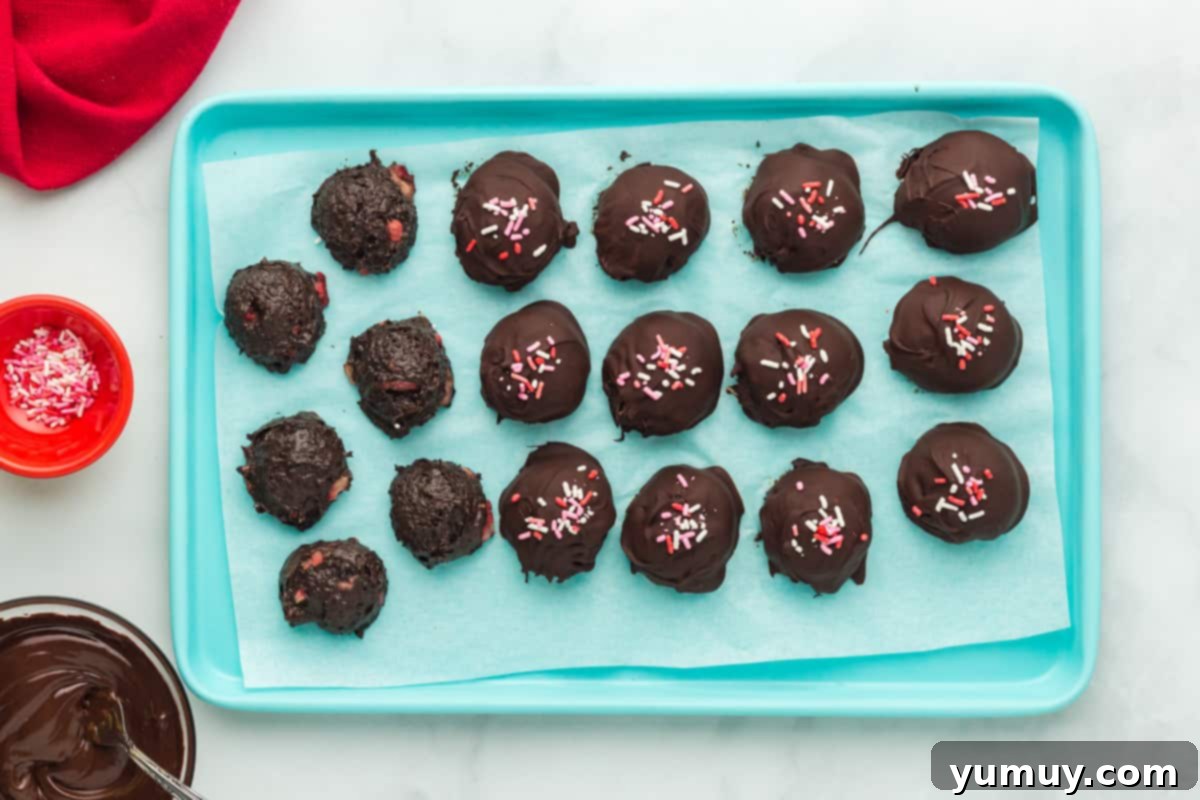 Beautifully finished chocolate strawberry truffles, perfectly coated and adorned with festive sprinkles.