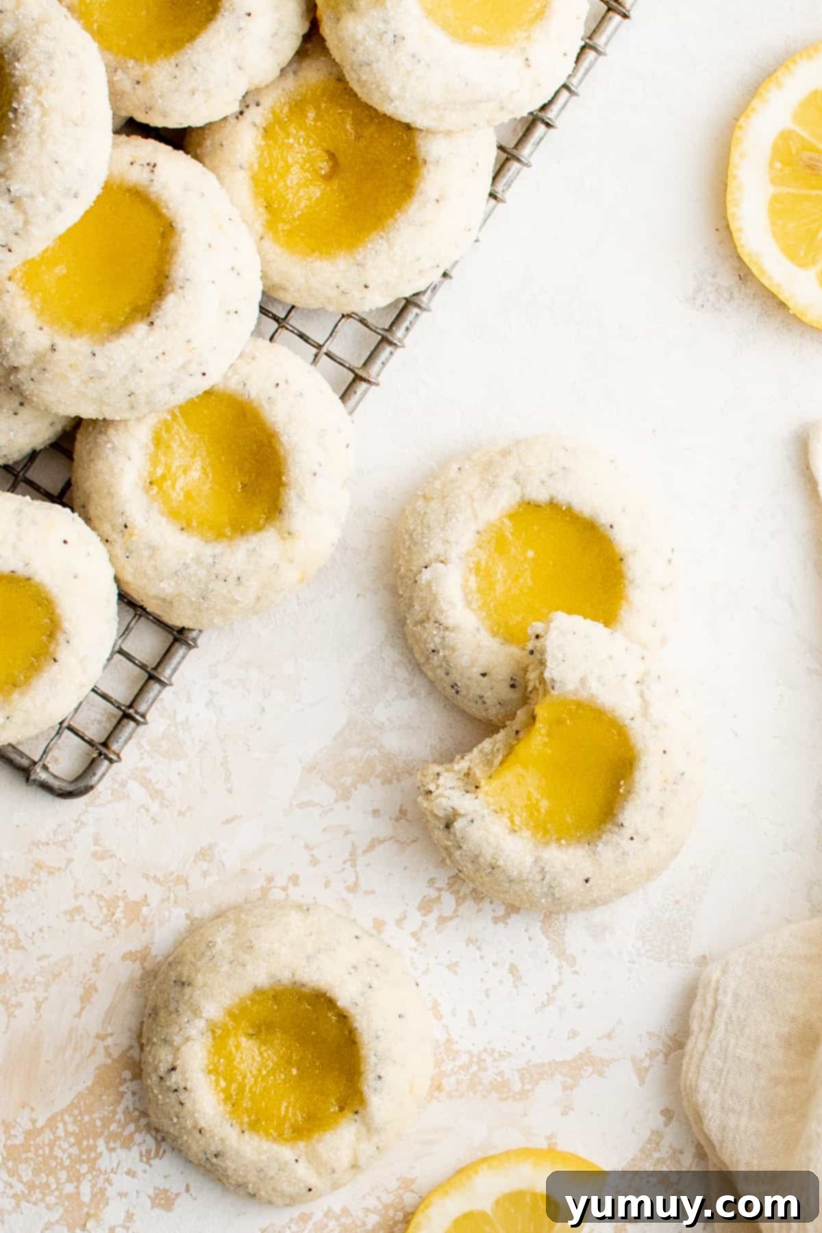Tangy Lemon Curd Delights 2 Delicious lemon curd thumbprint cookies on a cooling rack, glistening with tart lemon curd and ready to be enjoyed.