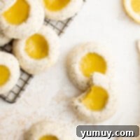 Tangy Lemon Curd Delights 4 Freshly baked lemon cookies on a cooling rack, adorned with lemon slices and radiating a golden glow.