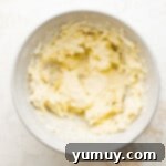 Tangy Lemon Curd Delights 5 Creamy butter in a mixing bowl on a clean white surface, perfectly whipped and ready for the next step.