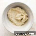 Tangy Lemon Curd Delights 6 A bowl filled with a soft, pale yellow lemon cookie dough, expertly mixed and ready for shaping.