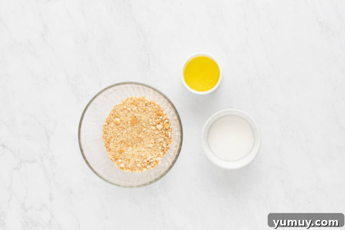 Close-up of finely crushed vanilla wafer cookies in a food processor, ready to be mixed with butter and sugar for the cheesecake crust.