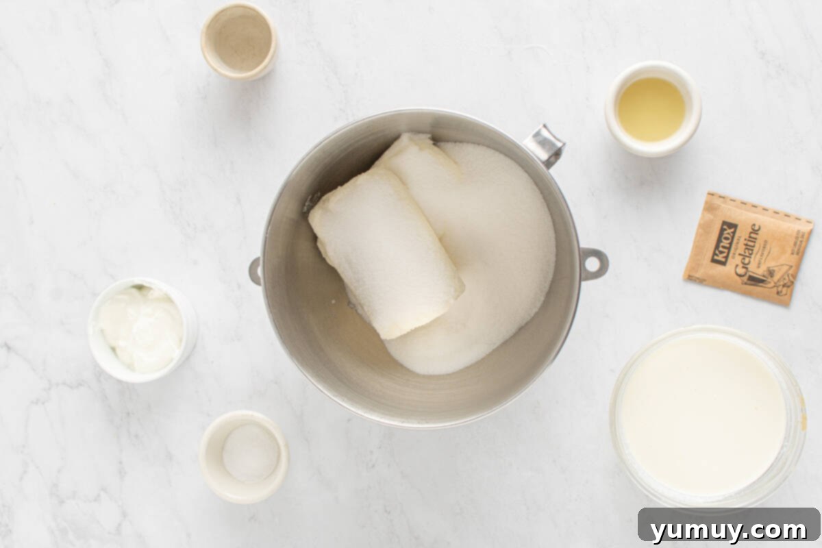Cream cheese and powdered sugar being thoroughly blended in a mixing bowl with an electric mixer, achieving a smooth and fluffy texture for the cheesecake filling.
