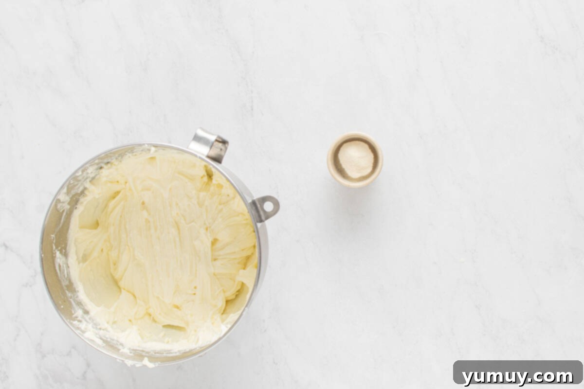 A large mixing bowl containing the whipped cream cheese mixture, showcasing its light and airy texture after the whipped topping has been carefully folded in.