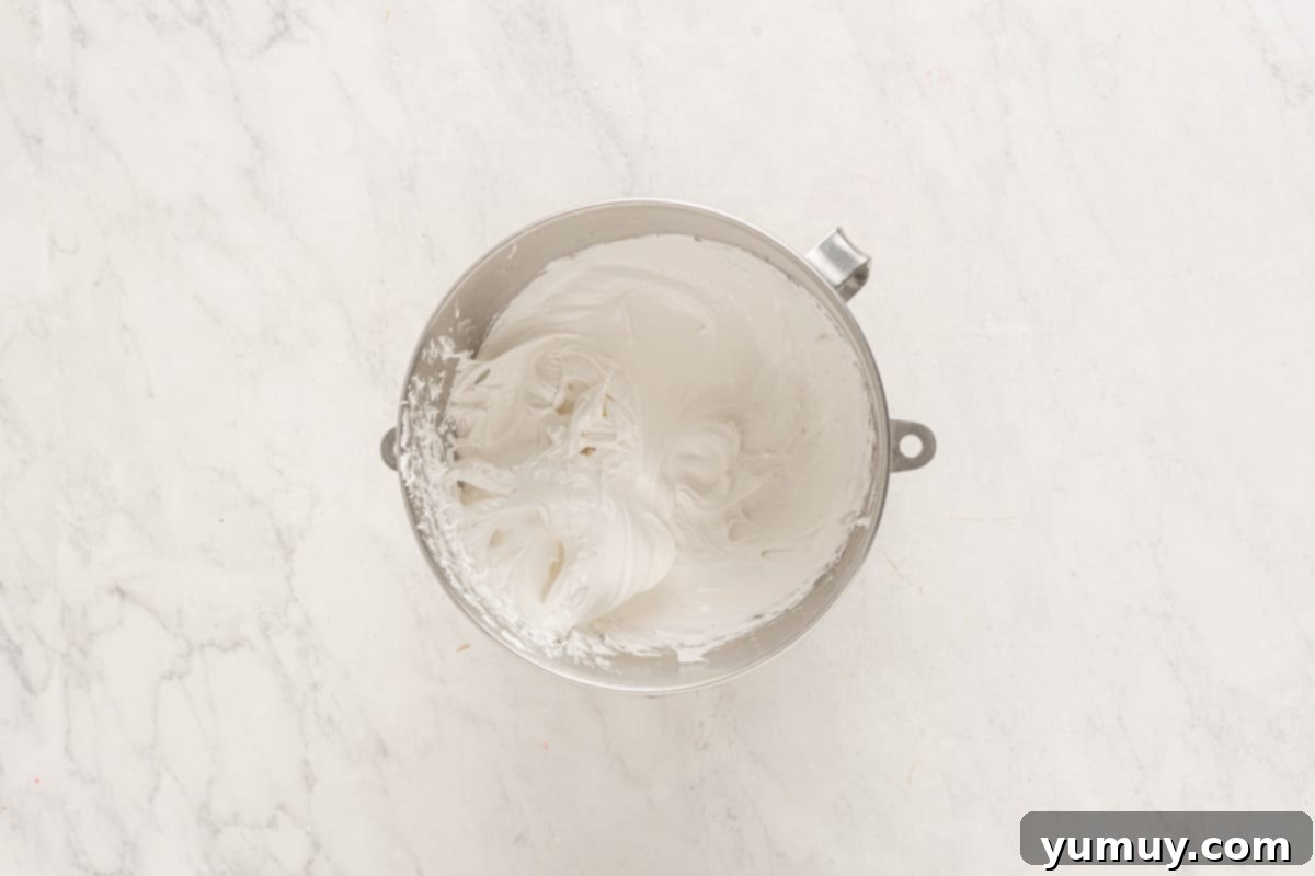 fluffy meringue in a stainless mixing bowl.