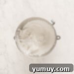 fluffy meringue in a stainless mixing bowl.