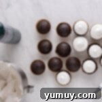 Overhead view of several chocolate cupcakes, some already frosted with elegant swirls of marshmallow meringue.