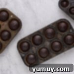 Freshly baked chocolate cupcakes still in their tins, ready to be cooled.