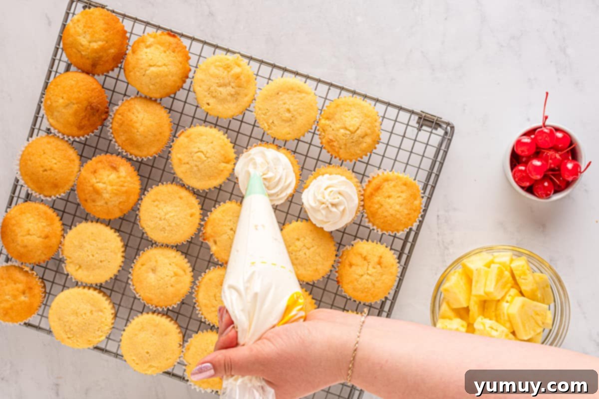 Frosting pineapple cupcakes.