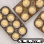 a group of muffin tins with dough in them.