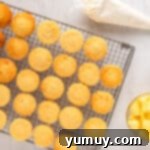 a tray of cupcakes on a wire rack next to butter.