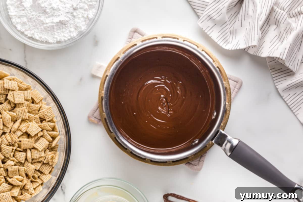 DIY Puppy Chow Perfection 7 Melted chocolate and peanut butter in a saucepan, ready to be mixed.